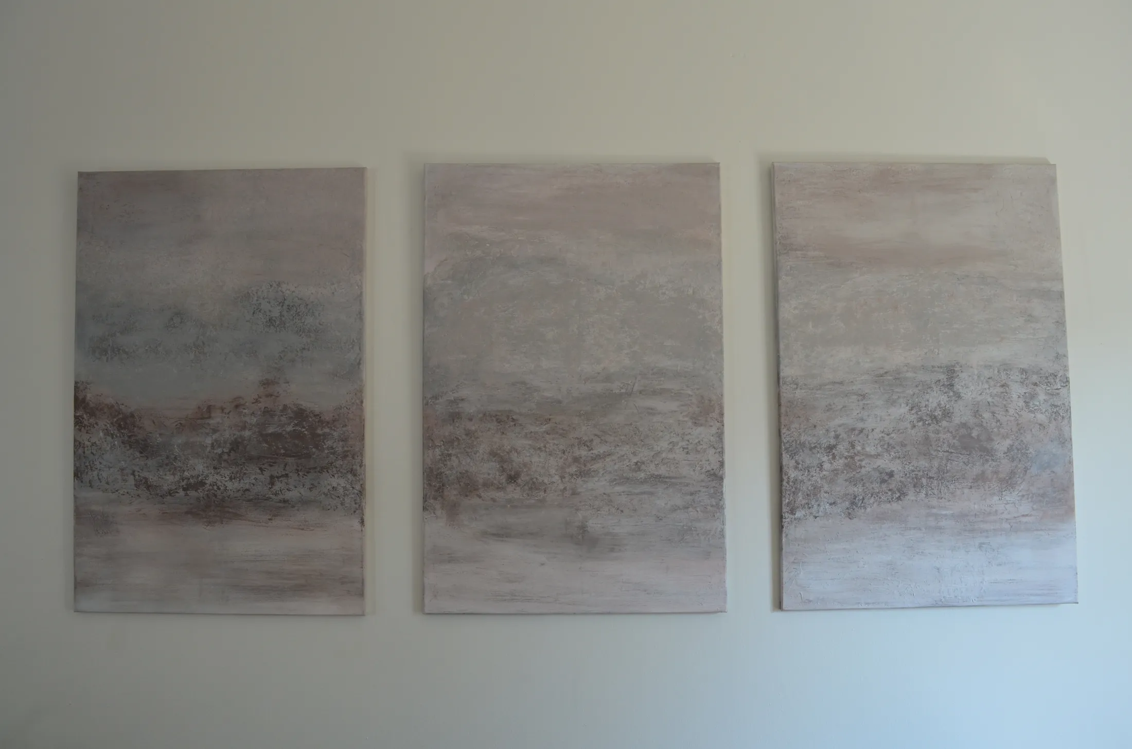 Misty Horizon — a three-panel textured triptych in soft dove-grey, dusty blush and warm taupe, displayed together on a gallery wall